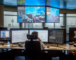 Man zit achter computerschermen in het controlecentrum van het Havenbedrijf Rotterdam